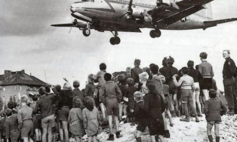 ברלינאים מביטים במטוס תובלה דאגלס C-54 סקיימאסטר) אמריקאי הנוחת בשדה התעופה של מערב ברלין (טמפלהוף)