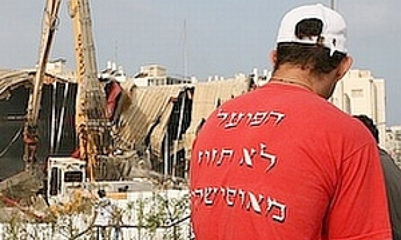 אוהד הפועל ת"א מביט בהריסות של אולם אוסישקין [צילום: ONE]