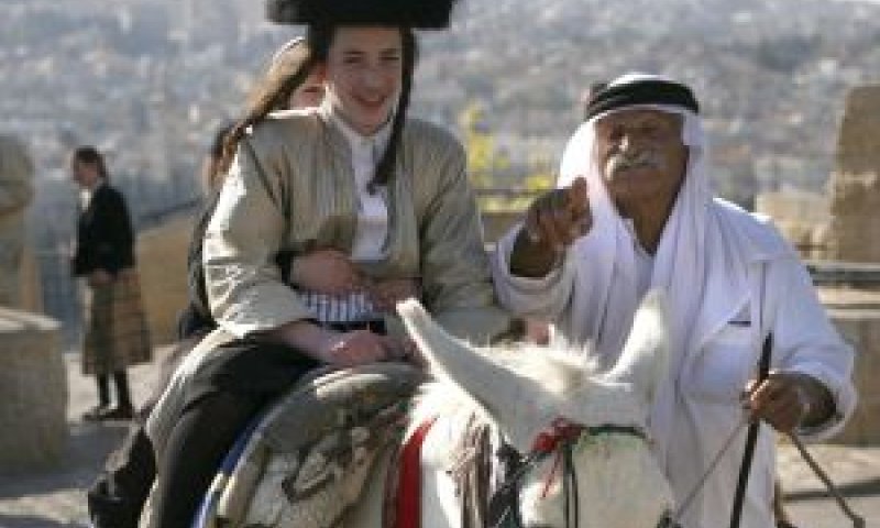 ערבי מנהיג חמור לבן ועליו רכובים שני ילדים חרדים. ברקע: נוף העיר העתיקה בירושלים. למצולמים אין קשר לכתבה [צילום: פלאש 90]