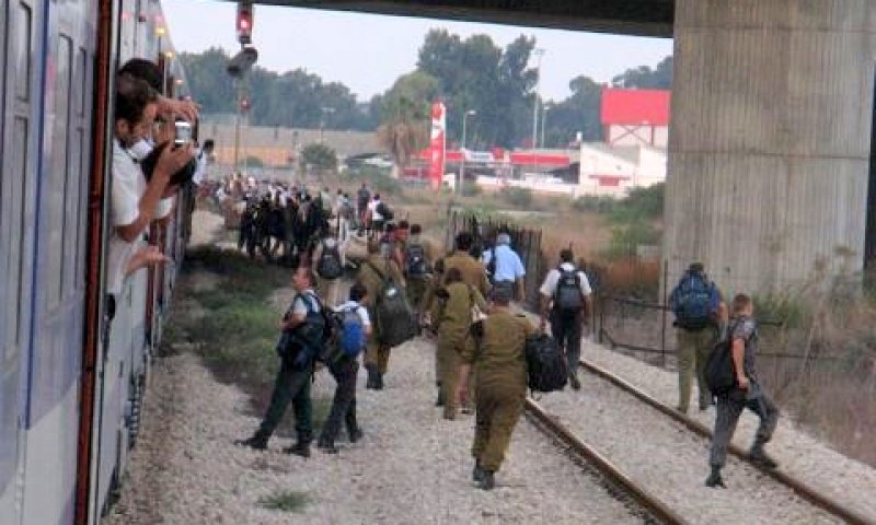 נוסעים יורדים מהרכבת שעצרה באמצע הדרך, אתמול [צילום: ארטיום דגל]