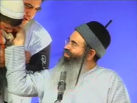 בזכות הקוקו. חיים מביא אל הרב ילד אפילפטי מאחת הנשים בקהל כדי שיברך אותו
