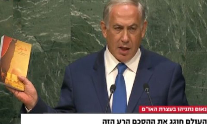 נתניהו וספרו של חמנאי [צילום: מן הטלוויזיה]