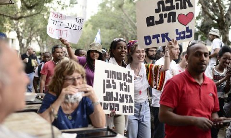 המחאה חולפת ליד בית קפה תל אביבי [צילום: תומר נויברג/פלאש 90]