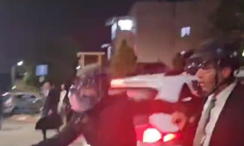 שוטר מחלץ את גרינברג מהאספסוף [צילום: שימוש לפי סעיף 27א לחוק זכויות יוצרים]