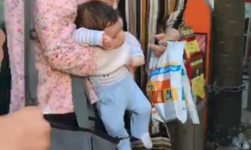 התינוק מוחזק בידי אמו לאחר ה"מרדף"