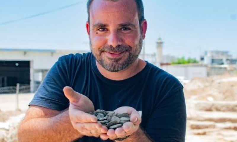 ארכיאולוג שחר קריספין מחזיק את מטמון המטבעות לאחר מציאתו [צילום: יולי שוורץ]
