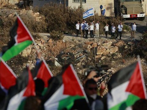 מפגינים ערבים נגד מתווה פראוור כשברקע צופים בהם תושבים מבית אל [צילום: AP]