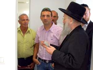 הרב אפרתי קובע מזוזה במשרדם של עדי ורני צים