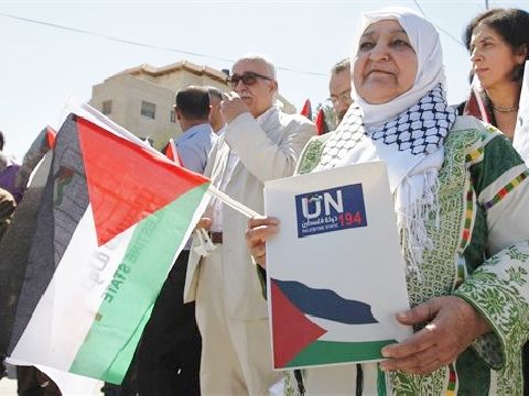 פעילה פלשתינית מגישה את מכתב ההכרה במטה האו"ם ברמאללה [צילום: AP]