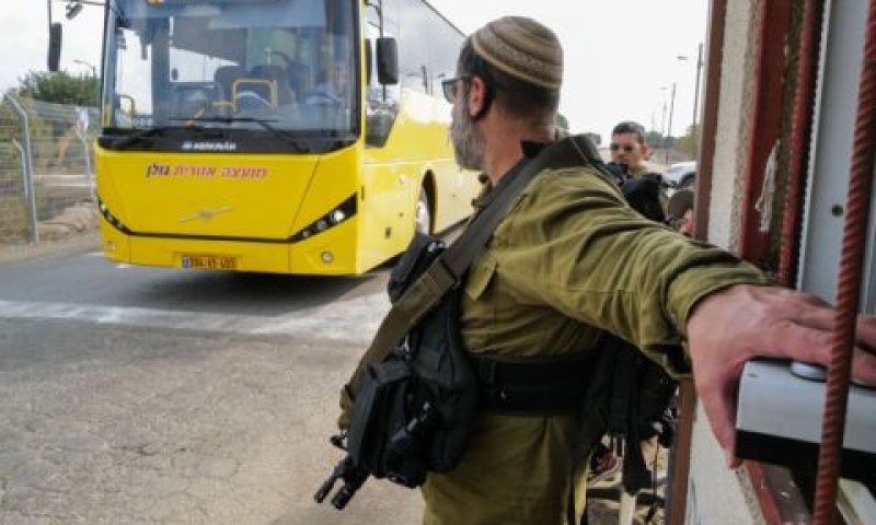 אוטובוס של המועצה האזורית גולן חולף ליד חייל ברמת מגשימים [צילום: מיכאל גלעדי/פלאש 90]