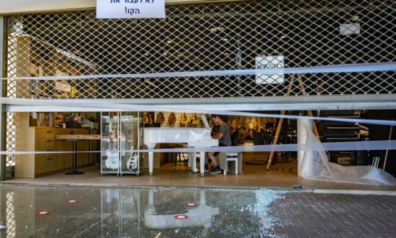 גבר מנגן בפסנתר בזירת פגיעת הטיל ברמת גן [צילום: אורן בן-חקון/פלאש 90]