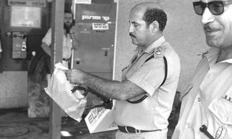 שוטר מוציא קליעים בזירת הפיגוע [צילום: משה מילנר/לע"מ]