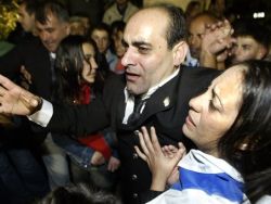 עזאם ואשתו עמאל מורמים ע"י ההמון בכפר [צילום: AP]