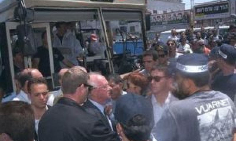 רבין על רקע האוטובוס החרוך [צילום: אבי אוחיון/לע"מ]