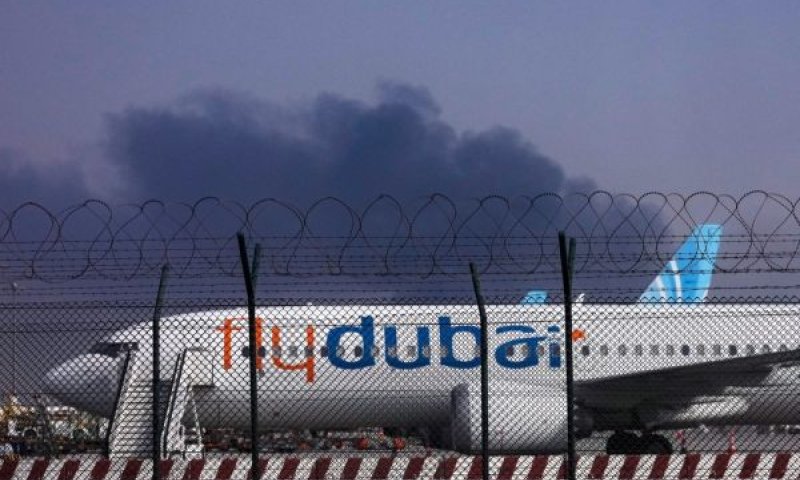 מטוס FlyDubai ברקע עשן מפגיעת כטב"ם [צילום: AP]