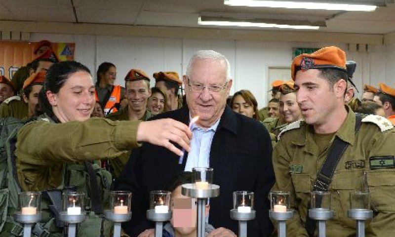 ריבלין מדליק נר עם לוחמת [צילום: מארק ניימן/לע"מ]