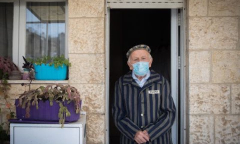 יוסף קליינמן (90) מציין בפתח ביתו את יום הזיכרון האחרון לשואה ולגבורה [צילום: יונתן זינדל/פלאש 90]