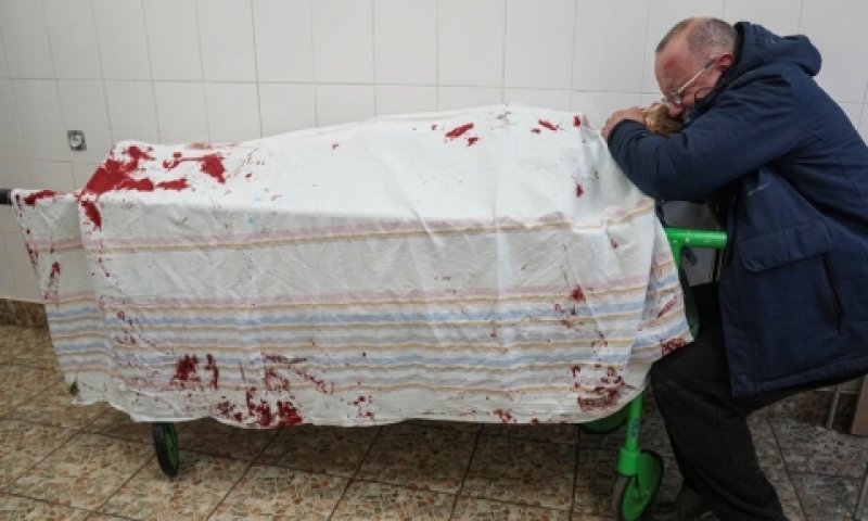 אב בוכה על גופת בנו בבית חולים במריופול [צילום: יבגני מלולטקה, AP]