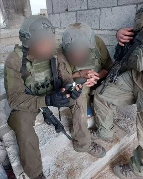 המחבל האזוק בין הלוחמים [צילום: תקשורת שב"כ]