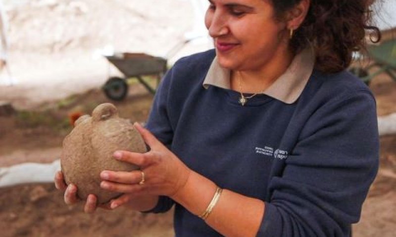 מעיין חמד, מנהלת החפירה מטעם רשות העתיקות בוחנת את אחד הכלים הקדומים [צילום: אמיל אלג'ם, רשות העתיקות.]