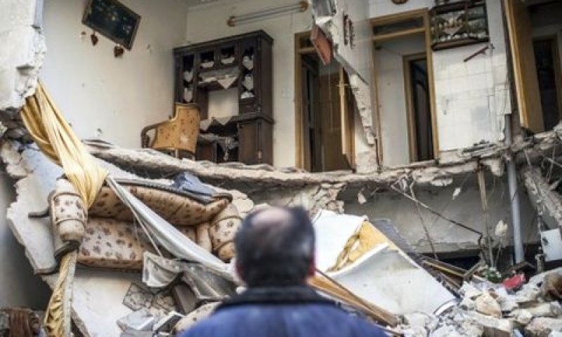 סורי ליד ביתו ההרוס שהופצץ [צילום: AP]