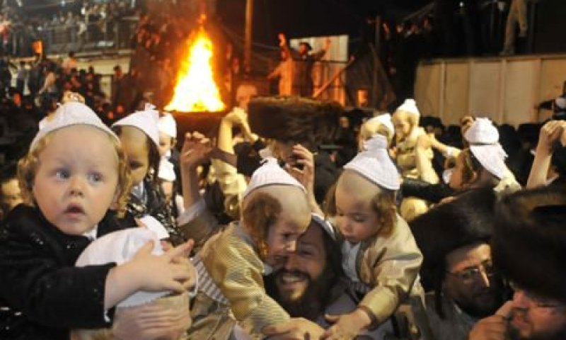 חסידי תולדות אהרון שמחים עם פעוטות בני 3 שהובאו למירון לטקס החלאקה בל"ג בעומר [צילום: פלאש 90]