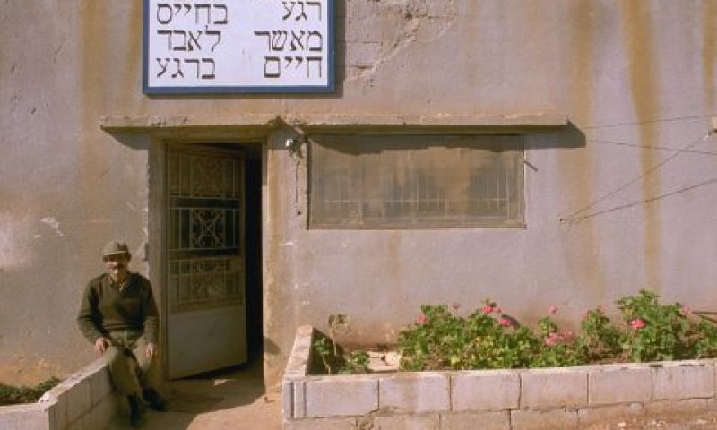 חייל מצבא דרום לבנון יושב בכניסה למבנה צה"לי ברצועת הביטחון בדרום לבנון (1989) [צילום: מגי איילון/לע"מ]