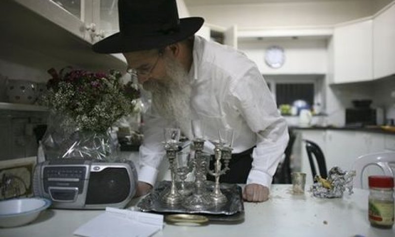 חסיד חב"ד המקורב למשפחתה של רבקה הולצברג מאזין לחדשות הרעות עם צאת השבת לאחר ההבדלה [צילום: AP]