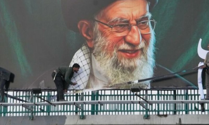 עובדים מציבים שלט חוצות על גשר ובו דיוקנו של המנהיג העליון האיראני המנוח, האייתוללה עלי חמינאי בטהרן [צילום: ואחיד סלמי/AP]