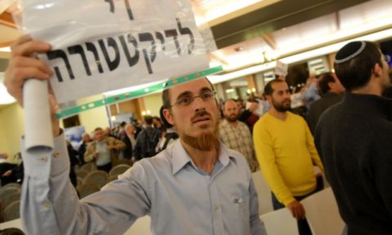 משתתף בכינוס הליכוד באריאל מניף שלט "די לדיקטטורה" [צילום: פלאש 90]