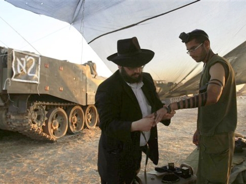 חבדניק מניח תפילין לחייל במצוות הרבי מלובביץ' [צילום: AP]
