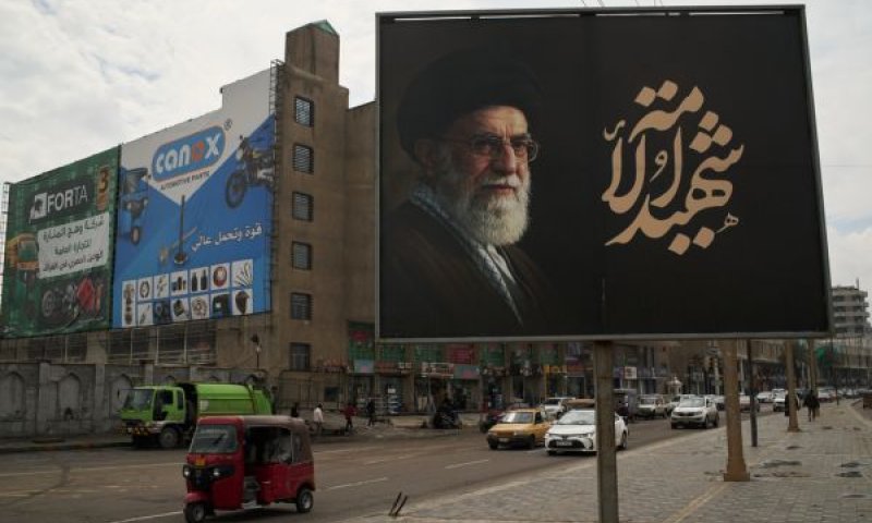 שלט בבגדד הנושא את תמונתו של עלי חמינאי [צילום: ליאו קוריאה/AP]