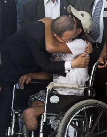 מחבק את אחד מפצועי המבצע [צילום: AP]