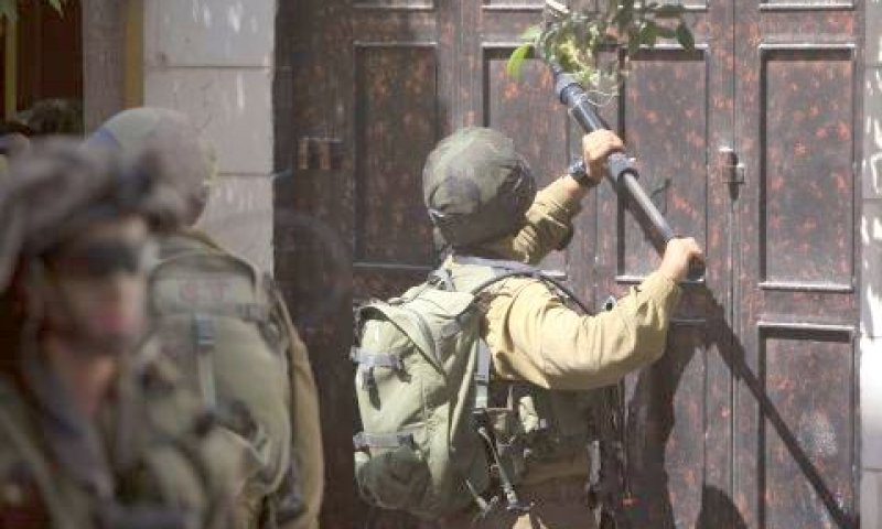 חייל שובר מנעול שער בחברון במהלך פעילות למעצר מבוקשים [צילום: AP]