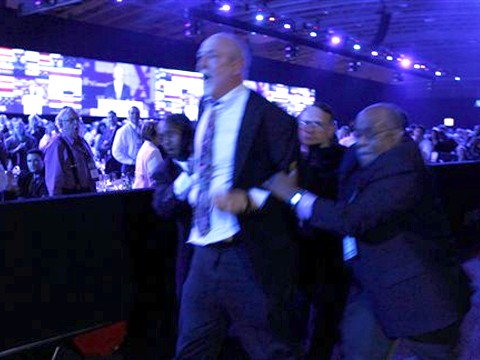 מאבטחים מוציאים מן האולם מפגין נגד נתניהו [צילום: AP]