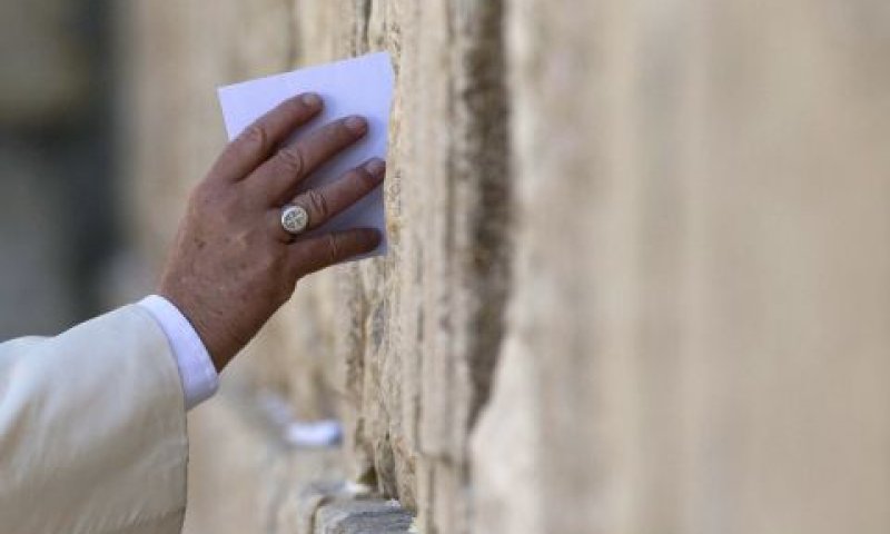 האפיפיור, ענוד בטבעת עם צלב, משלשל את הפתק בין החרכים [צילום: AP]