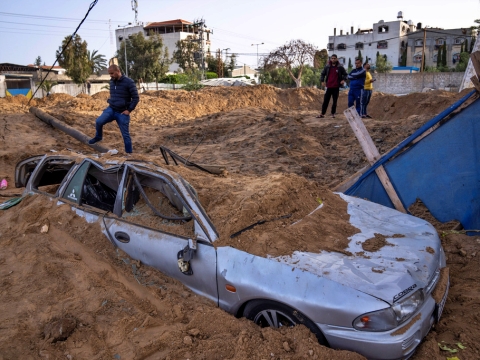 פלשתינים בוחנים את הנזק באחד מיעדי ההפצצה בעזה [צילום: פאטימה שבאייר, AP]