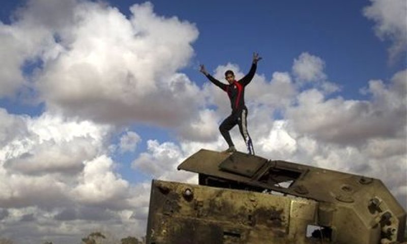נער לובי צוהל על טנק שהושמד מצבאו של קדאפי [צילום: AP]