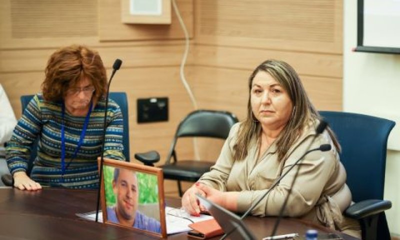 דבורה גונן לצד תמונת בנה שנרצח [צילום: יונתן זינדל/פלאש 90]