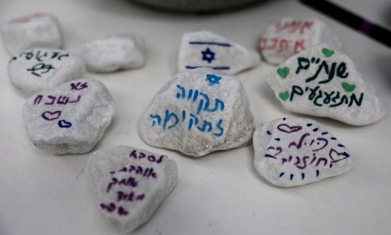 אבנים שהונחו בטקס הזיכרון של קיבוץ ניר עוז [צילום: צפריר אביוב/פלאש 90]