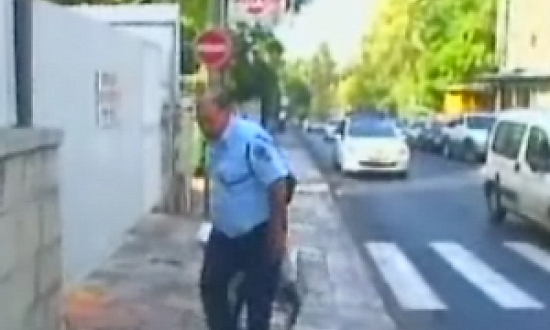 שוטר מוביל את מכשיר ההקלטה הגדול לחקירתו של ראש הממשלה
