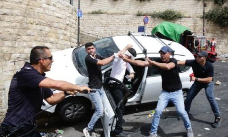 שוטר מחלץ באקדח שלוף את הפצוע [צילום: שלו שלום, TPS]