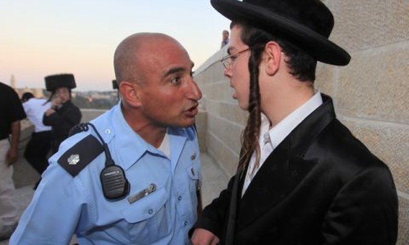 קצין משטרה מול מפגין חרדי [צילום: פלאש 90]