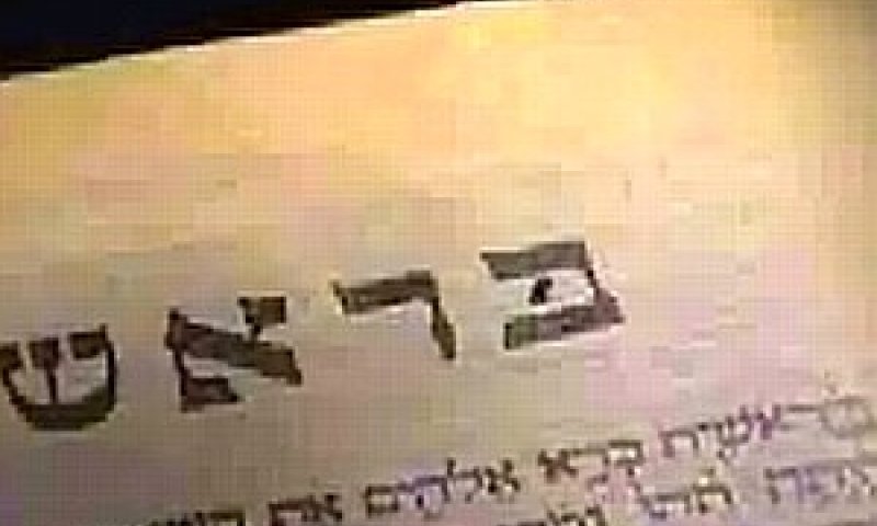 גודלו של הננו-תנ"ך הוא כגודל גרגיר אורז [בצילום: הננו-תנ"ך בתוך האות ב' של המילה בראשית]