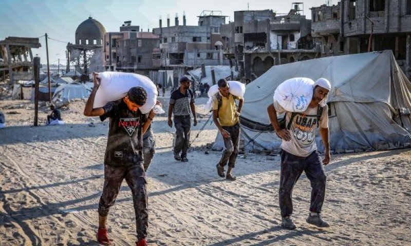 "אין רעב, יש תעמולה". תושבי ח'אן יונס נושאים שקי קמח שעברו דרך מעבר כרם שלום [צילום: עבד אל-רחים חטיב/פלאש 90]