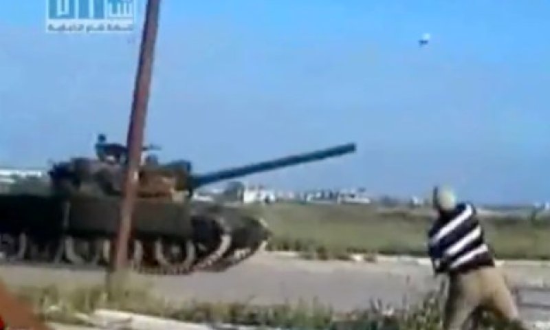 מפגין מיידה אבנים על טנק סורי [צילום: AP]