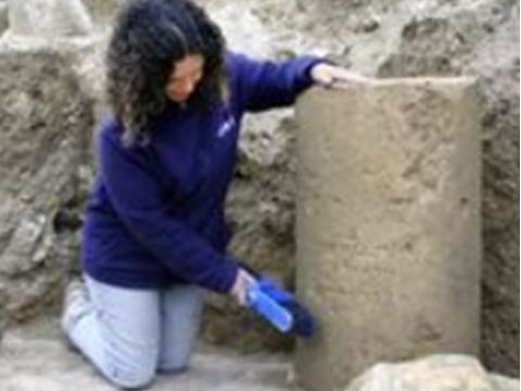 דנית לוי, מנהלת החפירה מטעם רשות העתיקות, ליד הכתובת כפי שנמצאה בשטח [צילום: יוֹלי שוורץ, רשות העתיקות]