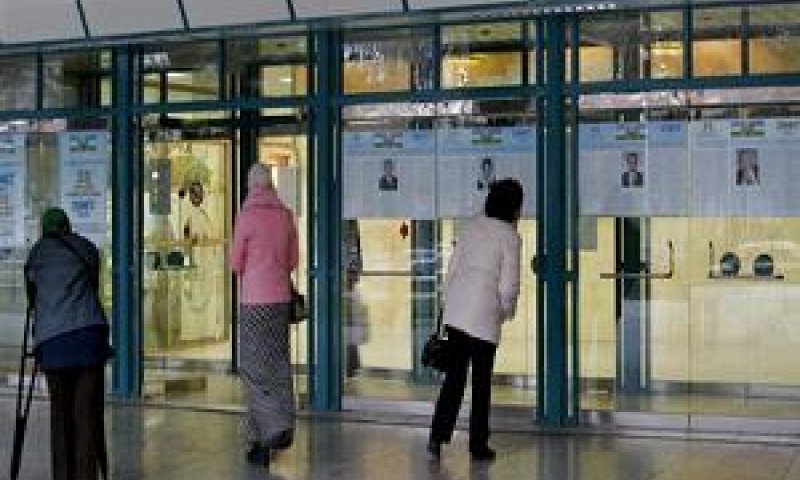 אזרחיות עבורות ליד מודעות בחירות בטשקנט, ערב הבחירות (צילום AP)