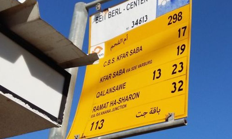 שילוט דו-לשוני בתחנת אוטובוס. מאחור - העברית
