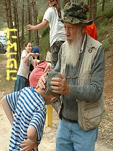 [פרופ' אומן מברך נכדו שרגלו מגובסת לאחר שמעד ונפל. צילום: באדיבות עיתון הצופה]